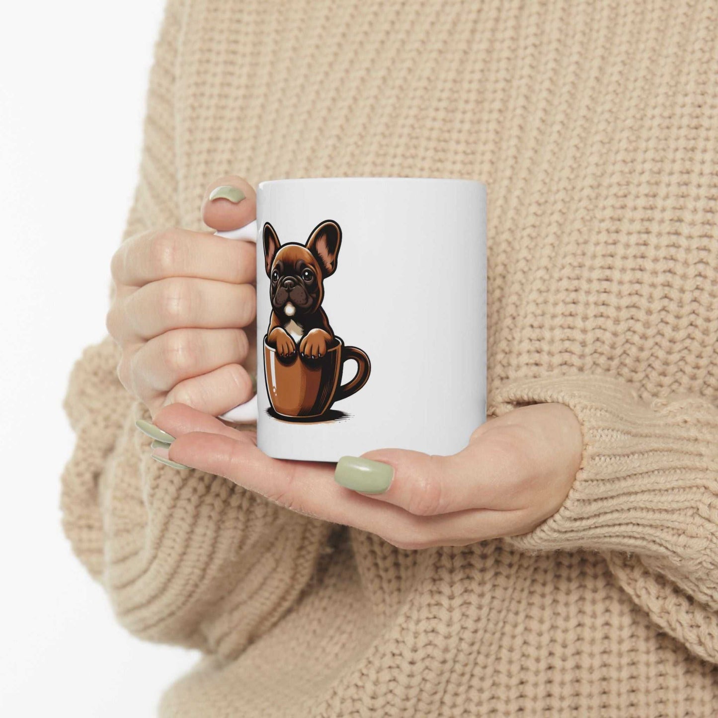 Person holding a mug with a dog design, wearing a beige sweater.