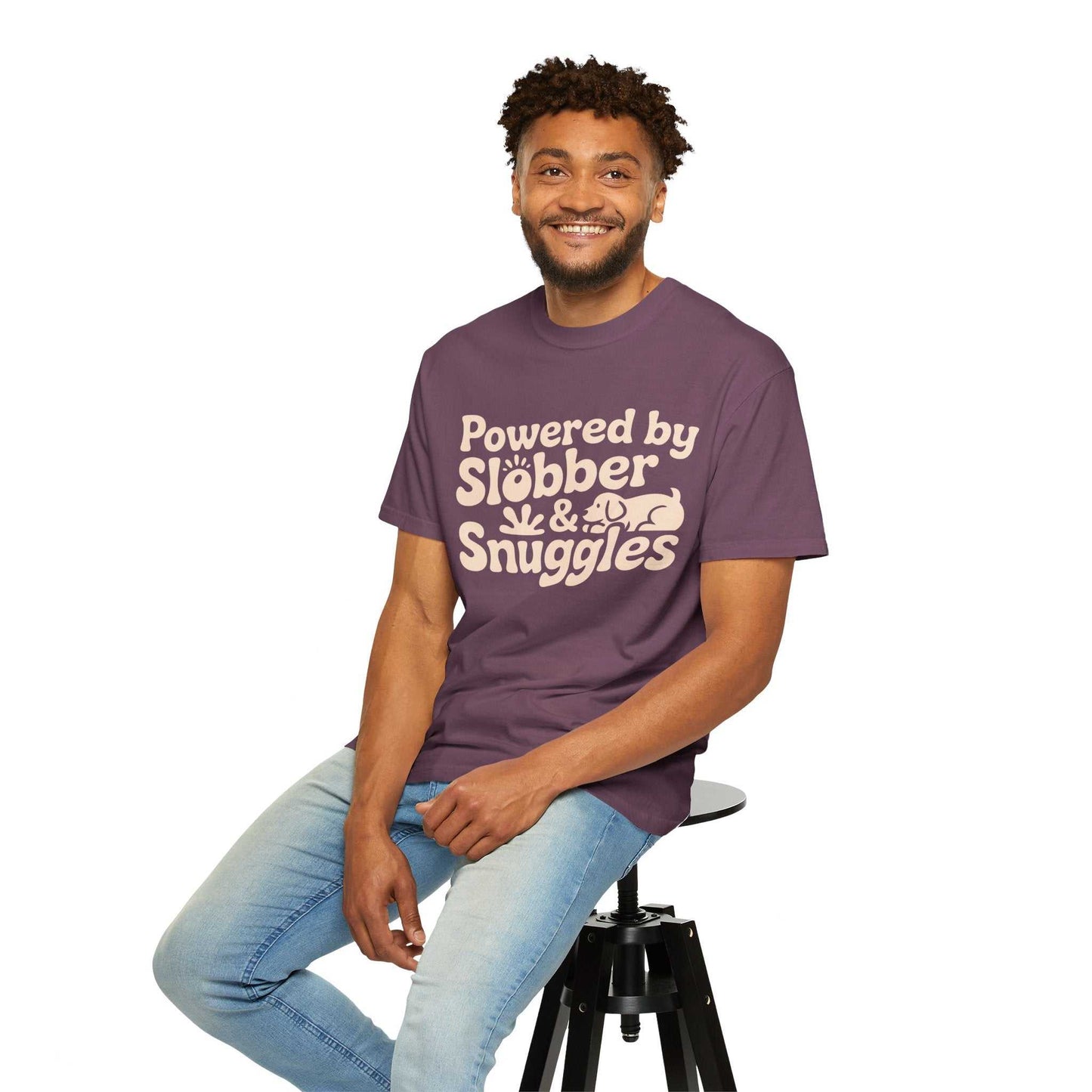 Man wearing a purple t-shirt with text sitting on a stool against a white background