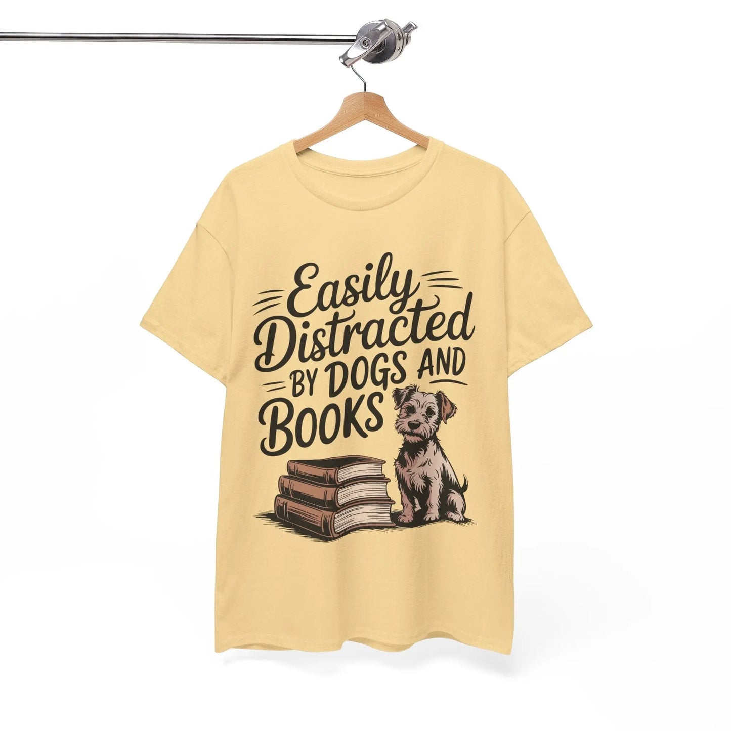 Yellow t-shirt with a graphic of a dog and books and text 'Easily Distracted By Dogs And Books' on a hanger.