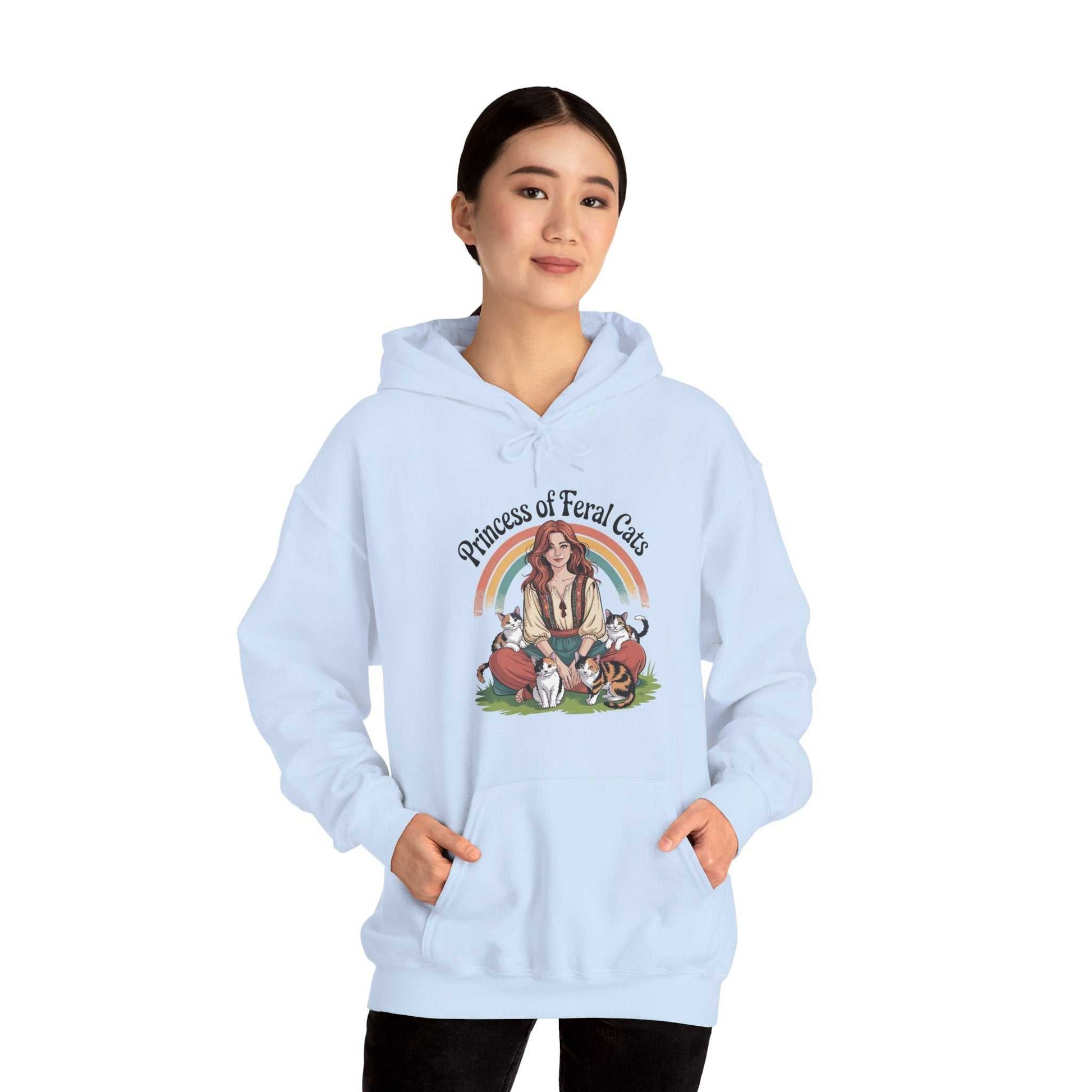 Light blue hoodie with a graphic design of a woman and cats on a white background