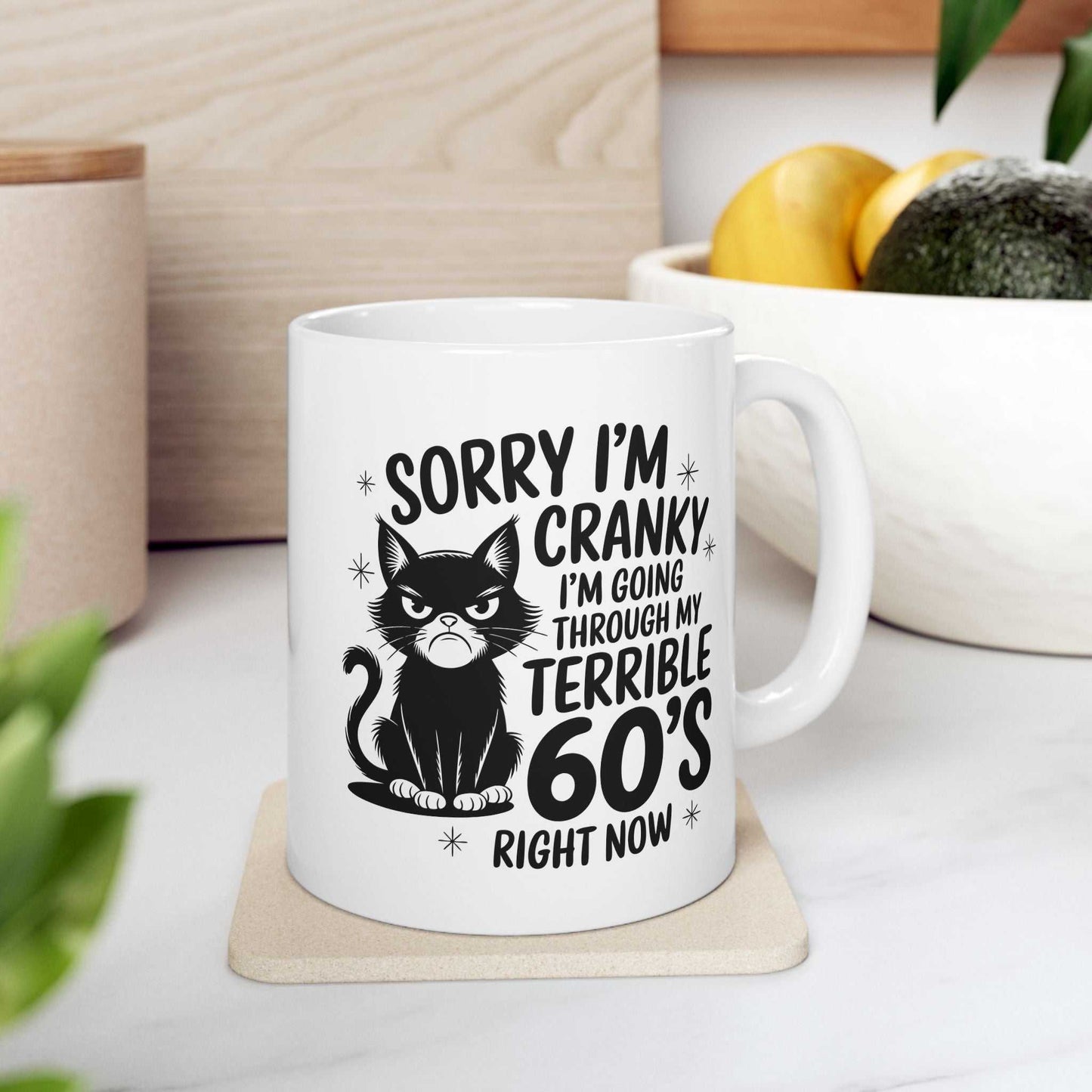 White mug with a black cat graphic and humorous text on a white surface.