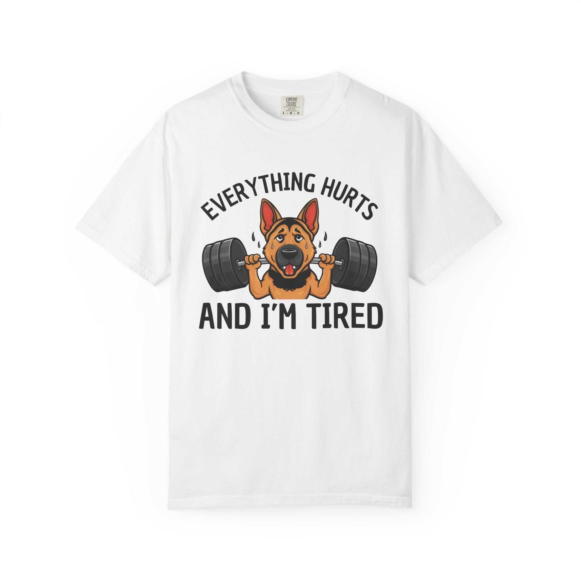 White t-shirt with a graphic of a dog lifting weights and text 'Everything hurts and I'm tired' on a white background.