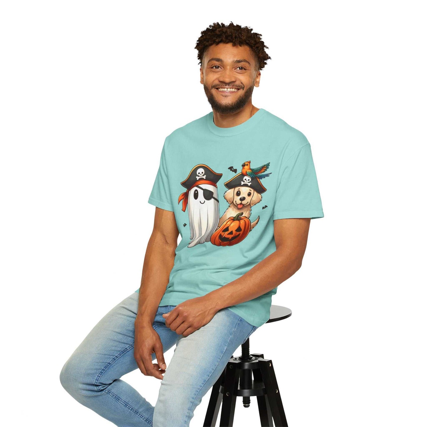 Man wearing a light blue t-shirt with Halloween-themed graphics, sitting on a stool against a white background.