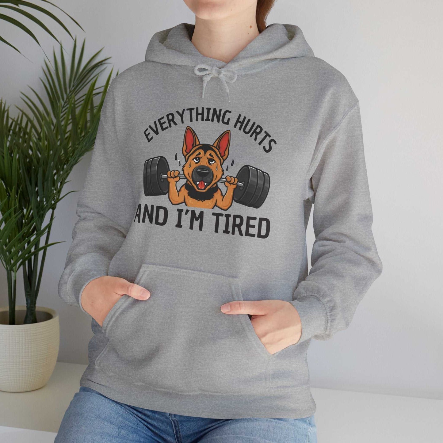Person wearing a gray hoodie with a dog lifting weights graphic and text.