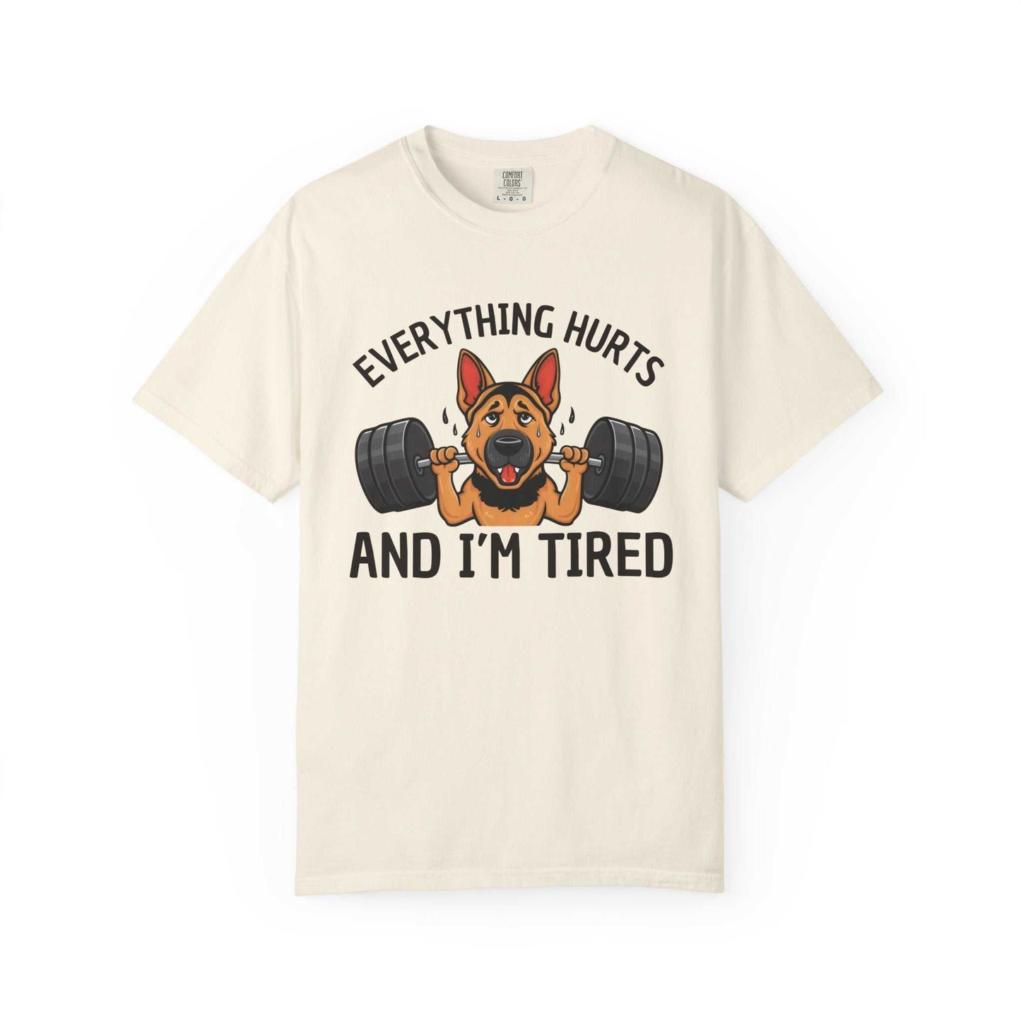 Beige t-shirt with a graphic of a dog lifting weights and text 'Everything hurts and I'm tired' on a white background.