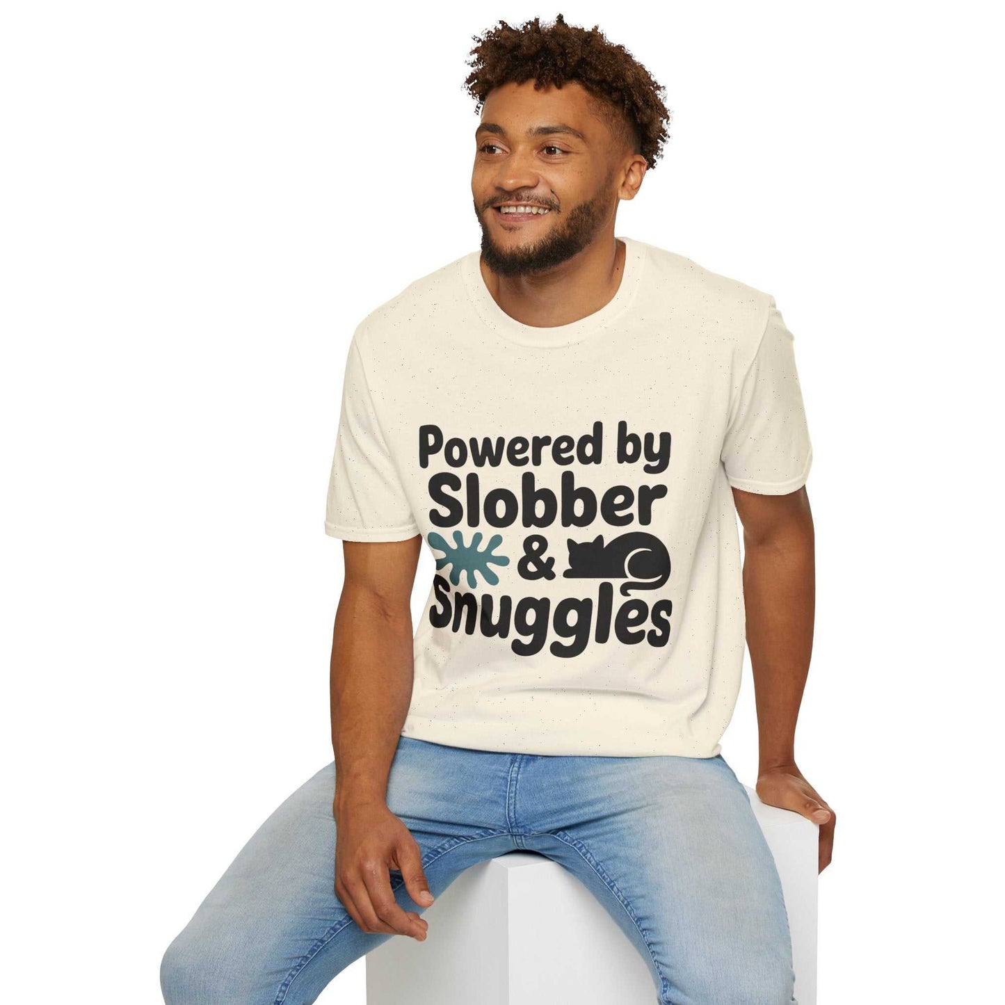 Man wearing a t-shirt with 'Powered by Slobber & Snuggles' text and graphic, sitting on a white stool.