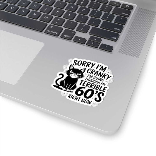 Laptop with a sticker featuring a cat and text on the palm rest area.