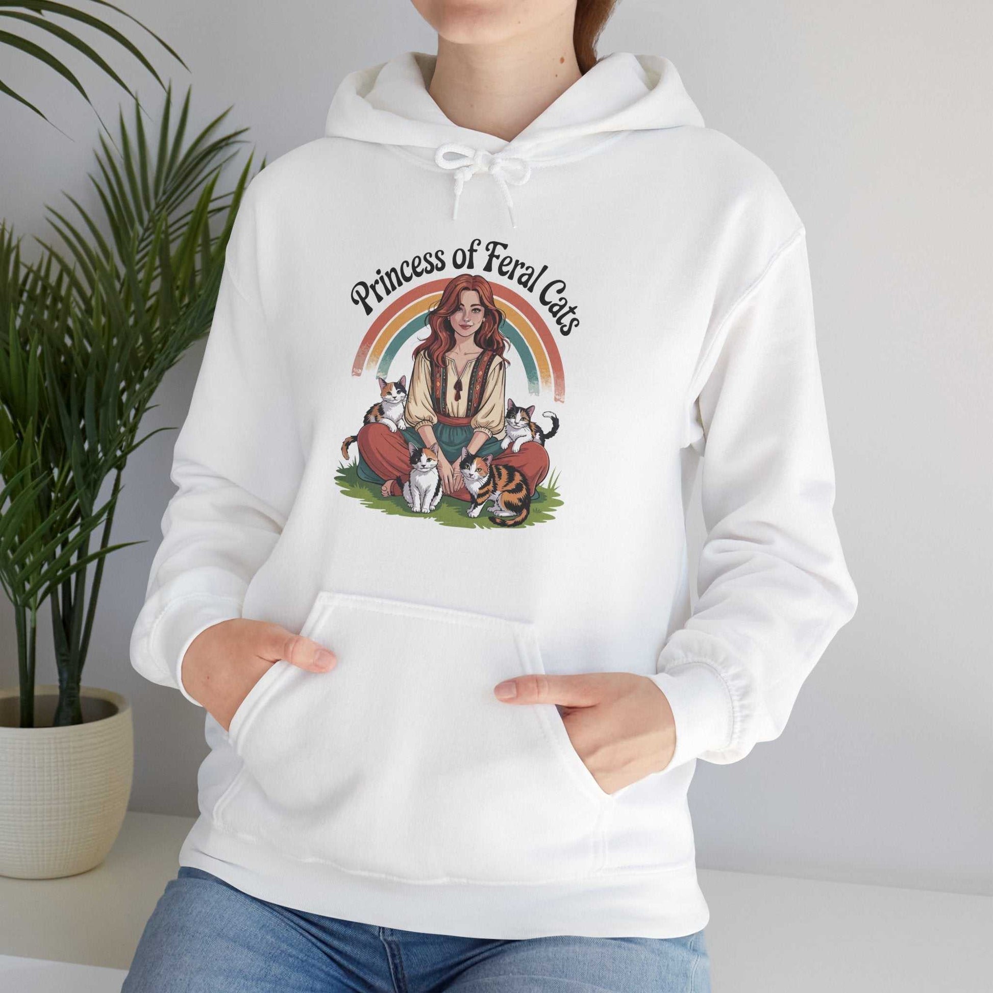 White hoodie with 'Princess of Feral Cats' design worn by a person, with a plant in the background.