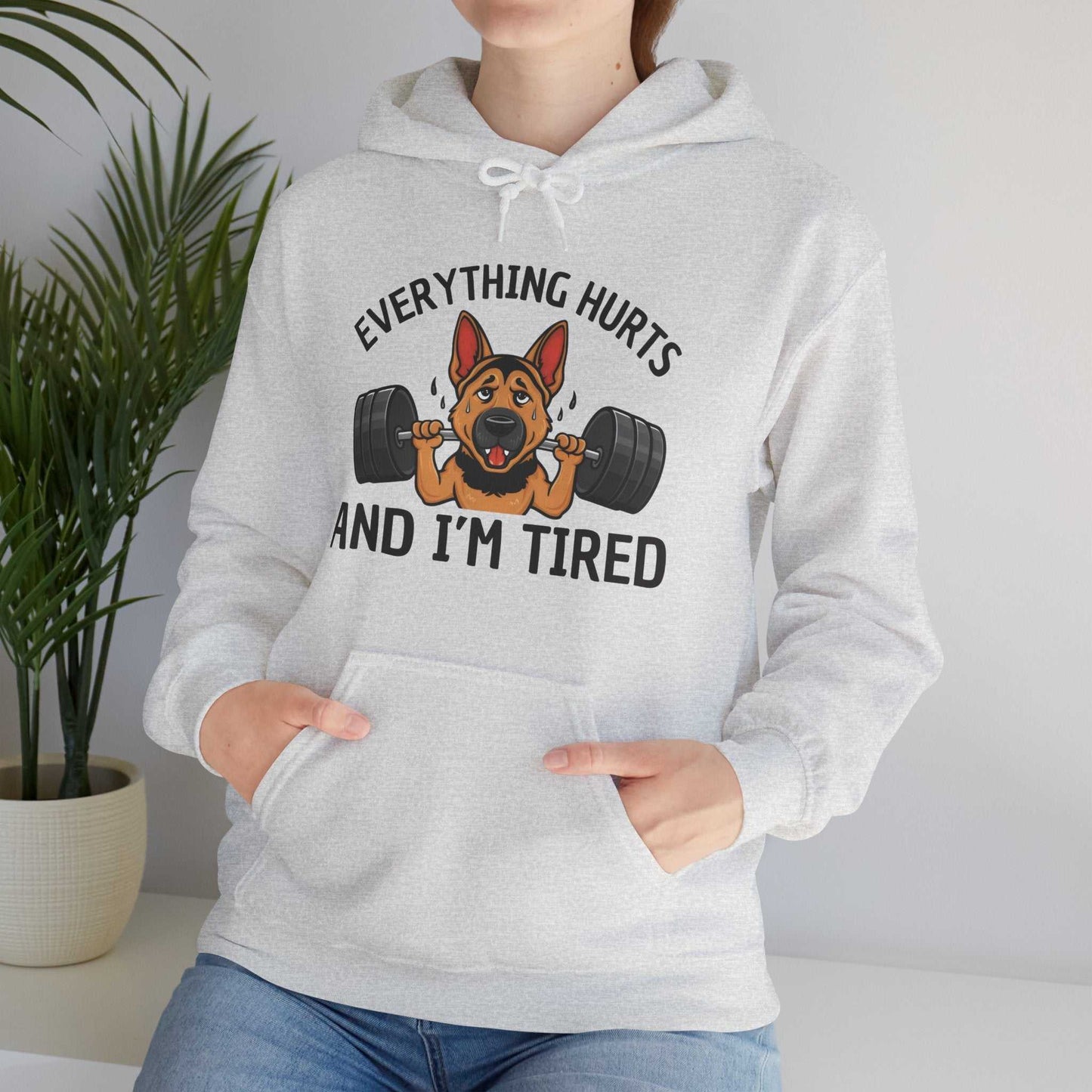 Person wearing a gray hoodie with a dog lifting weights graphic and text.