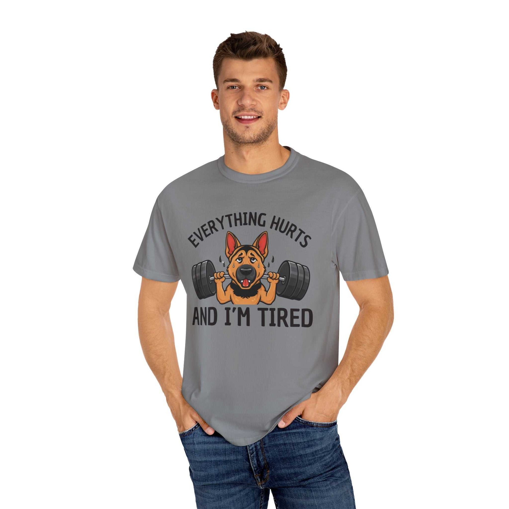 Man wearing a gray t-shirt with a dog lifting weights graphic and text on a white background