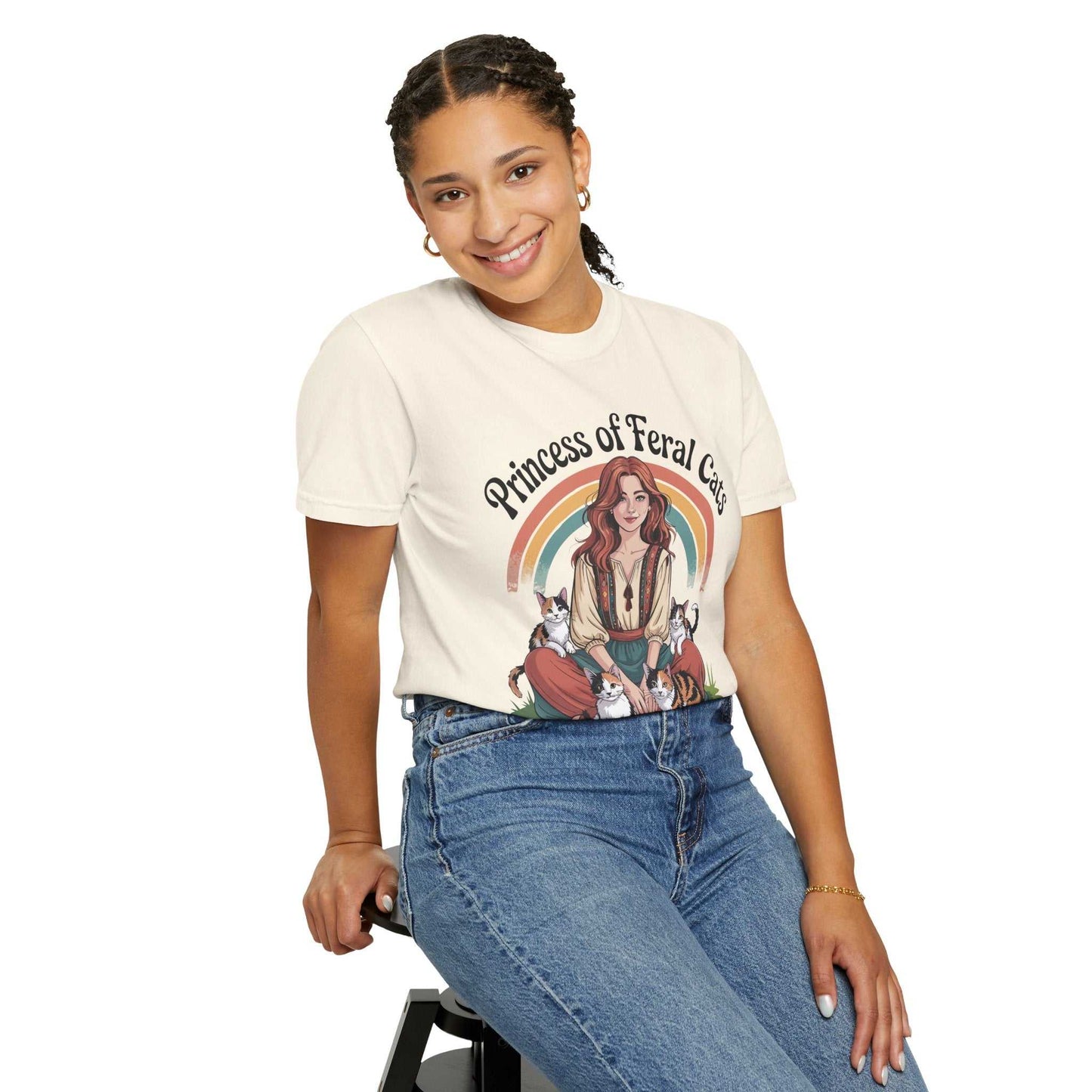Person wearing a t-shirt with a graphic design and text, sitting on a stool against a white background