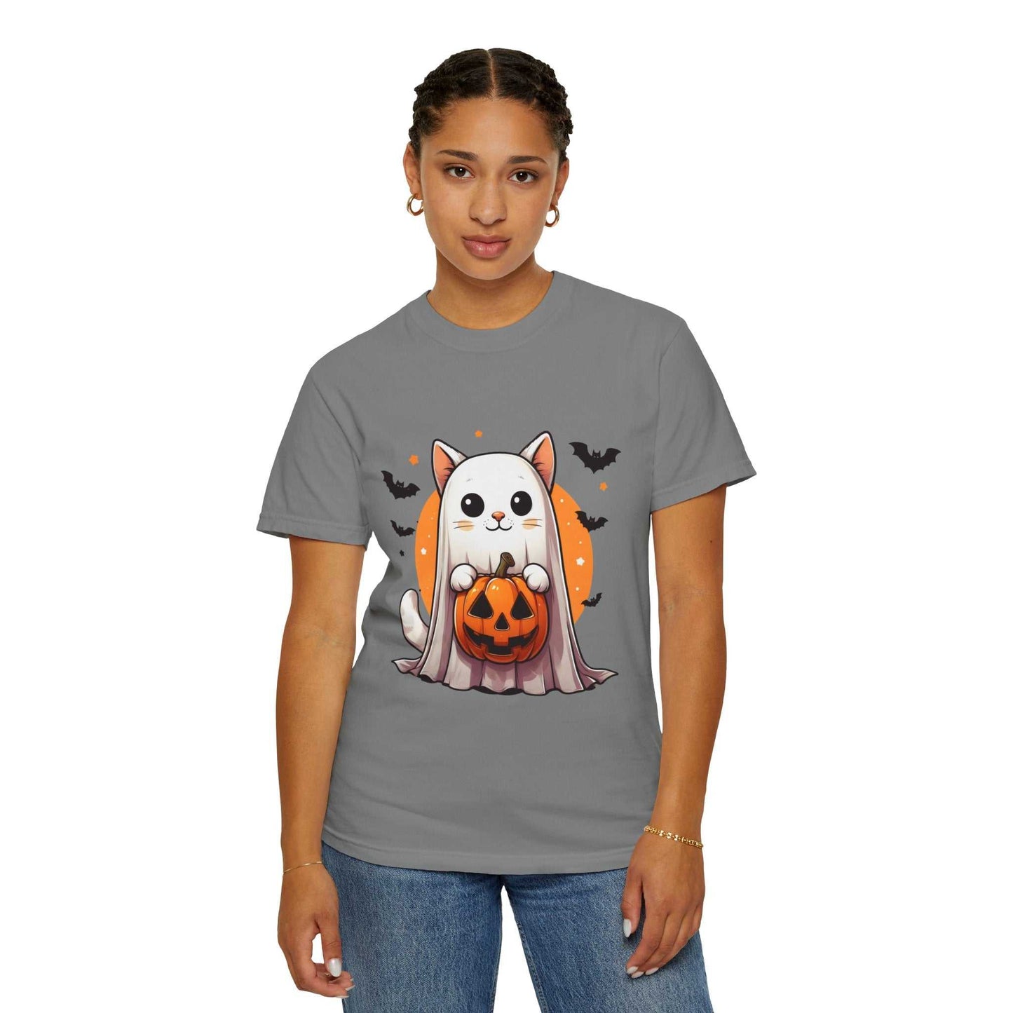 Person wearing a gray t-shirt with a Halloween-themed design of a cat in a ghost costume holding a pumpkin.