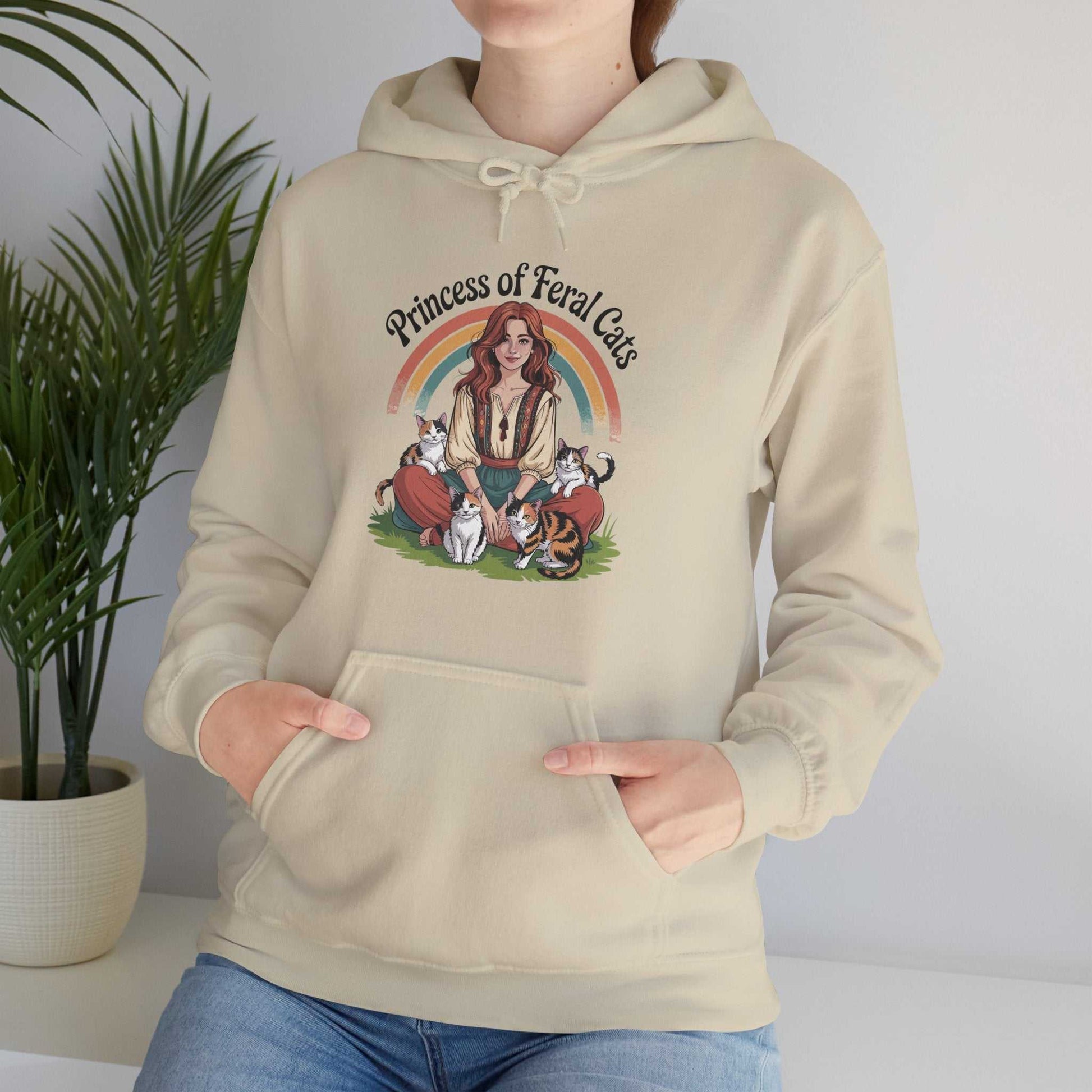 Beige hoodie with 'Princess of Feral Cats' design featuring a woman and cats, worn by a person.
