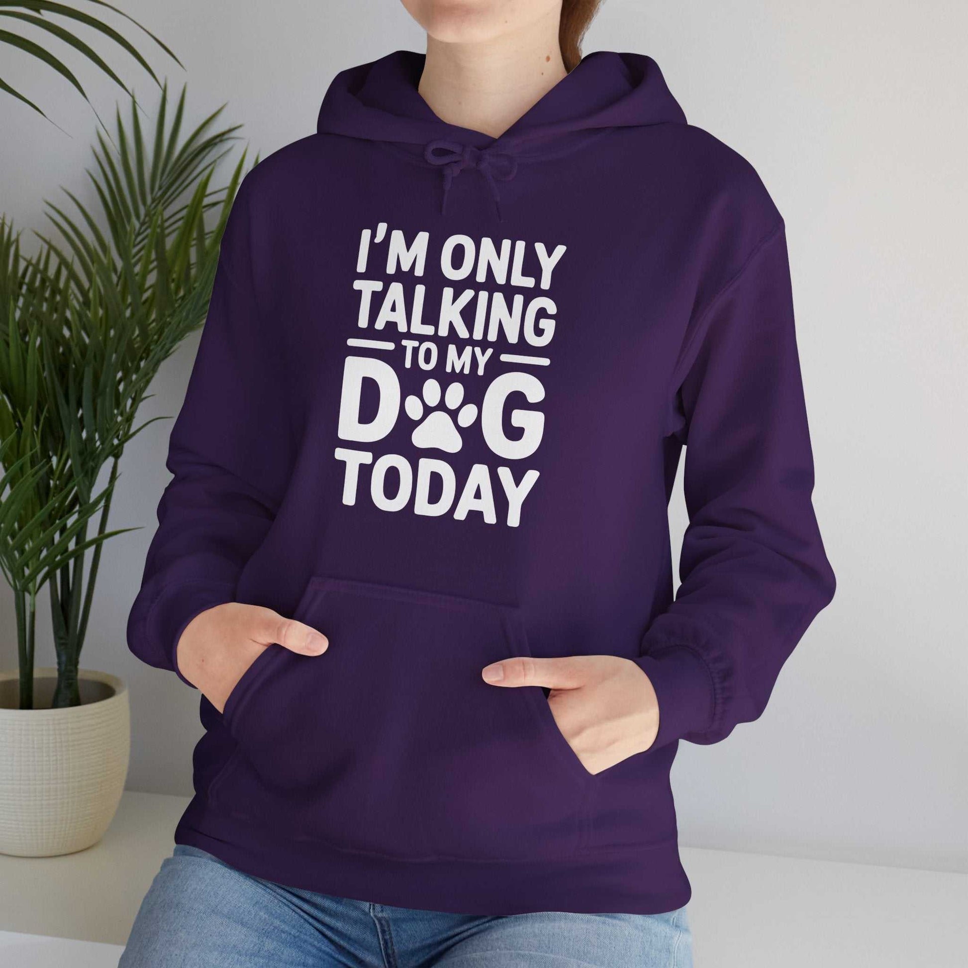 Person wearing a purple hoodie with text 'I'm only talking to my dog today' in a home setting.