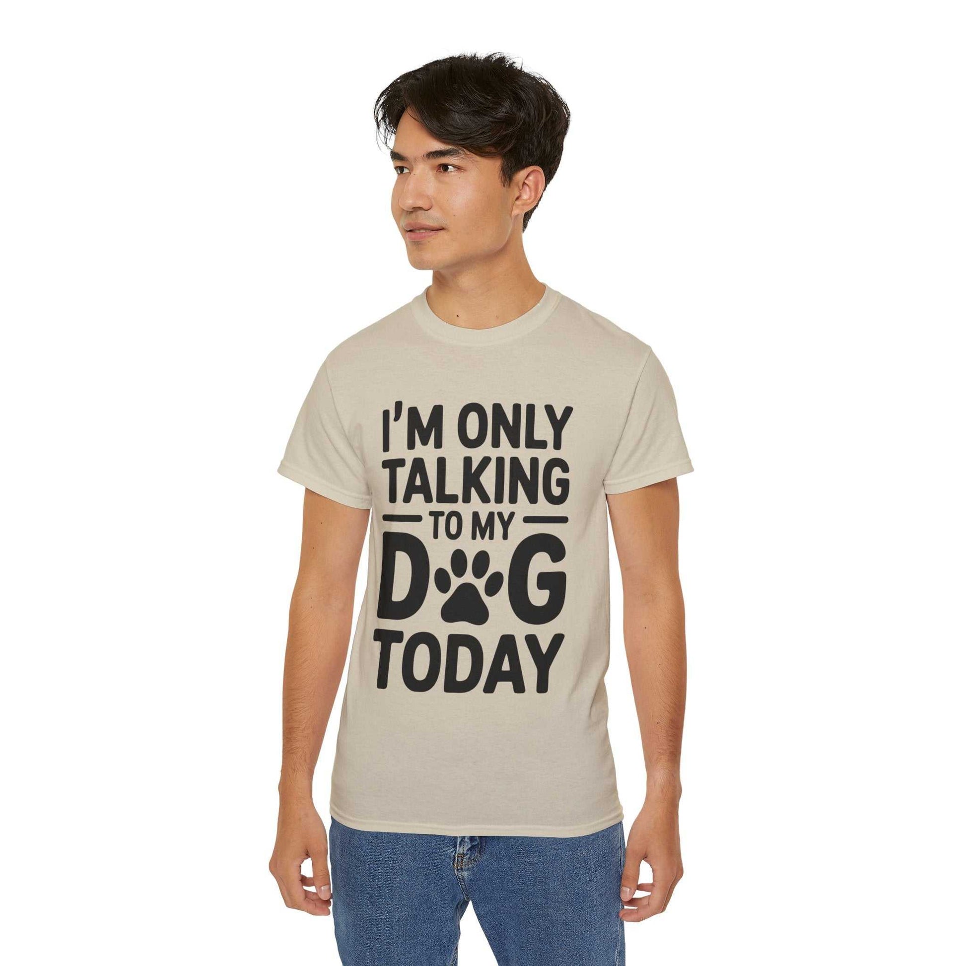 Person wearing a beige t-shirt with text 'I'm only talking to my dog today' on a white background