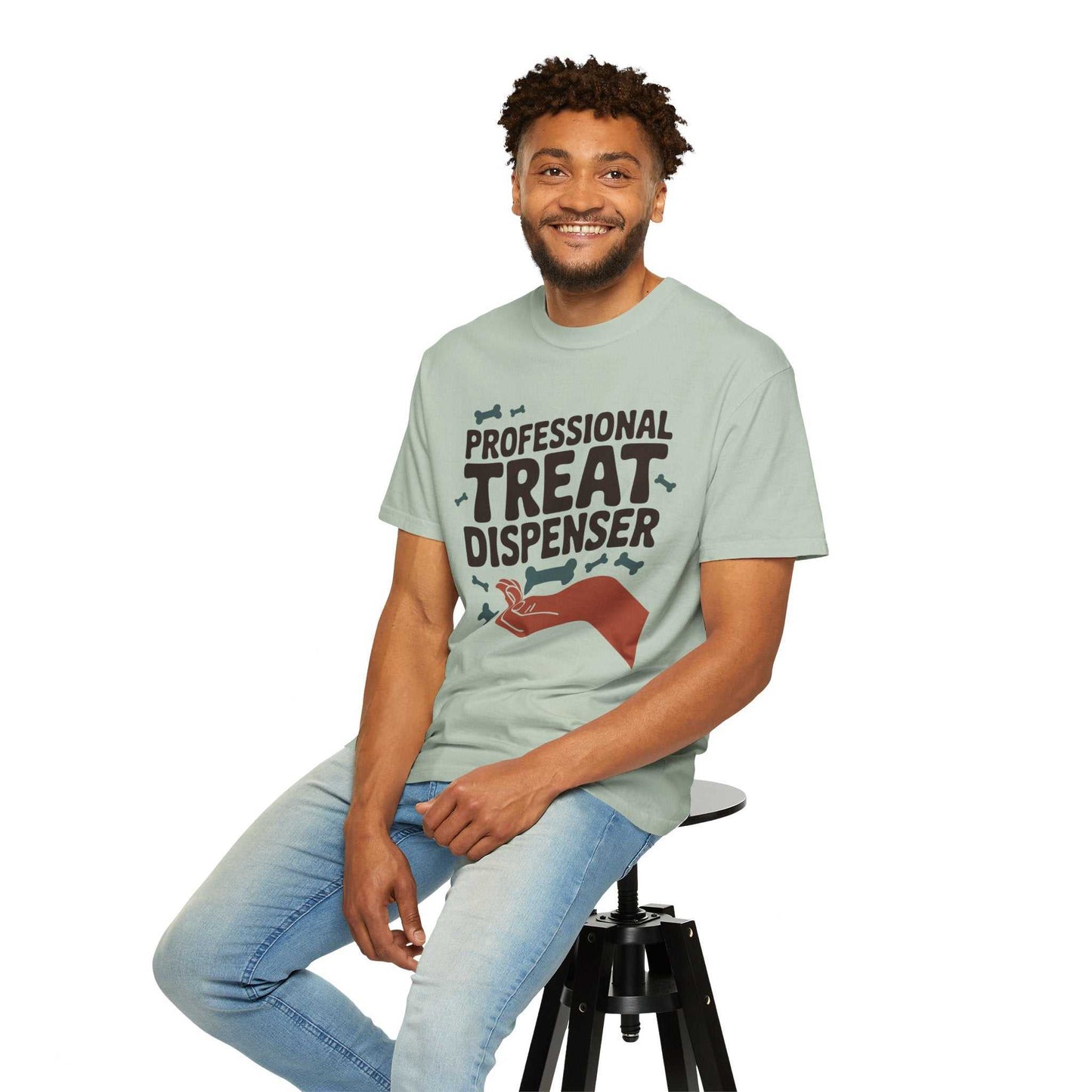 Man wearing a light green t-shirt with text and graphic, sitting on a stool against a white background