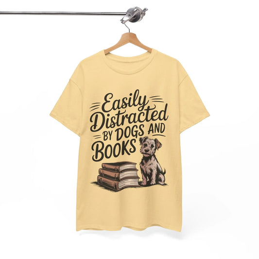 Yellow t-shirt with a graphic of a dog and books and text 'Easily Distracted By Dogs And Books' on a hanger.