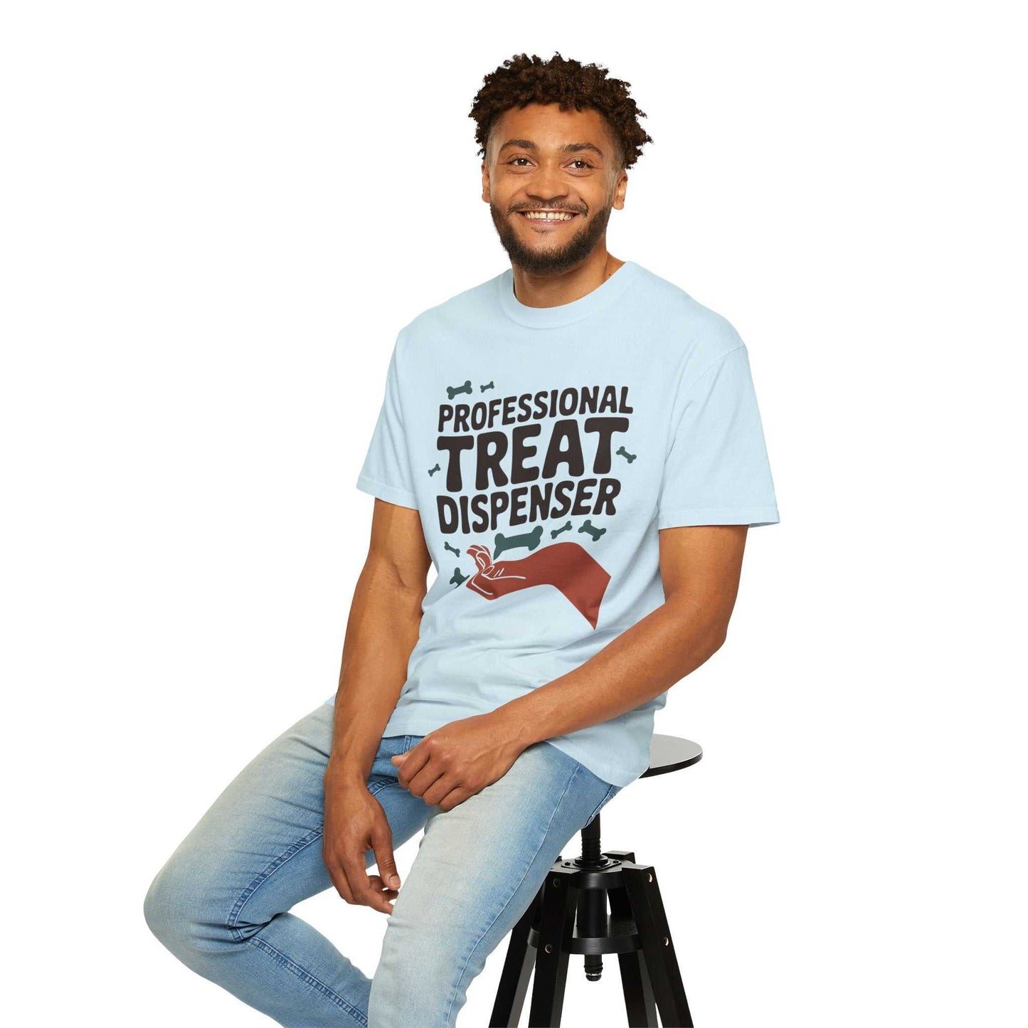 Man wearing a light blue t-shirt with text and graphic, sitting on a stool against a white background