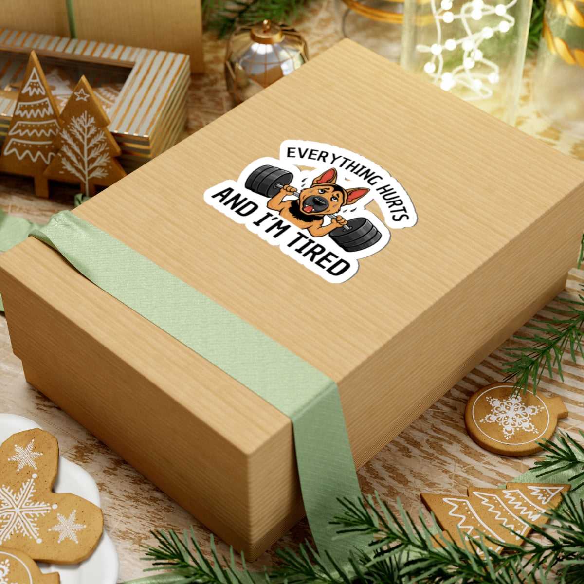 Wooden gift box with a humorous sticker on a festive background with cookies and lights.