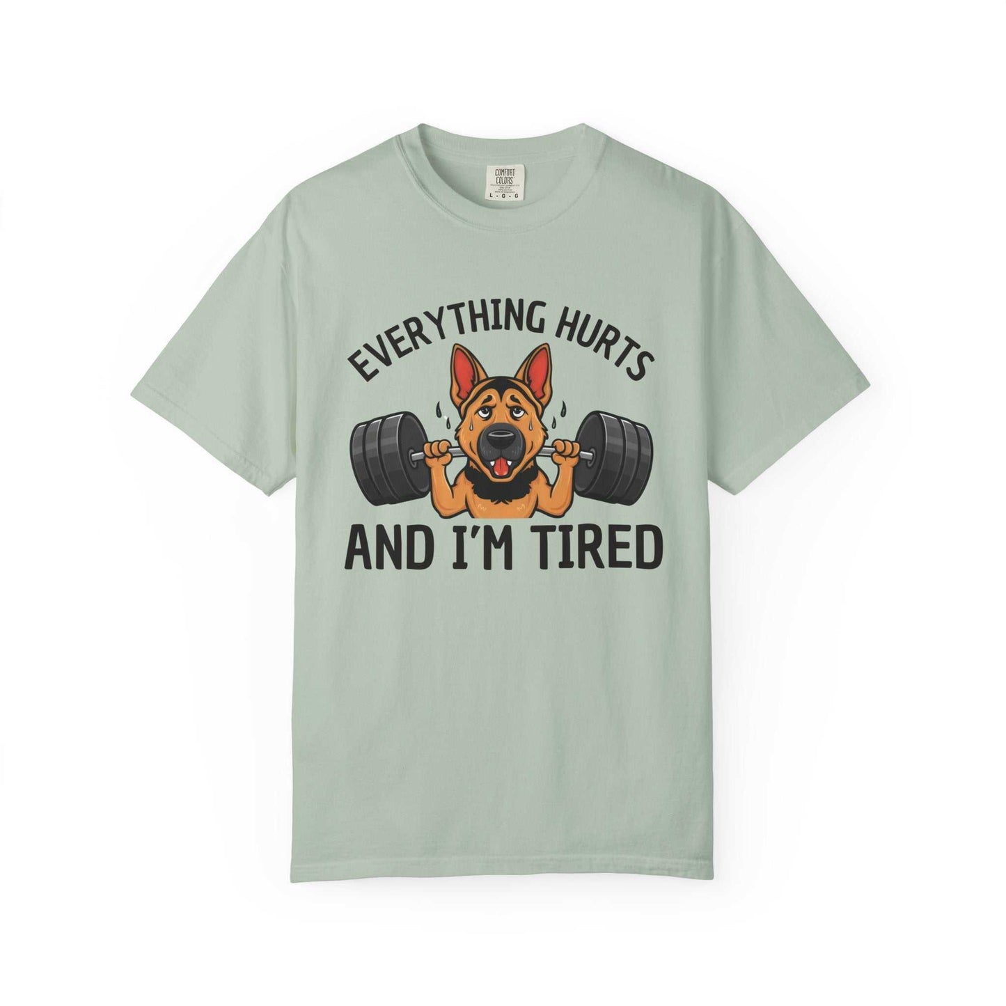 Light green t-shirt with a graphic of a dog lifting weights and text 'Everything hurts and I'm tired' on a white background.