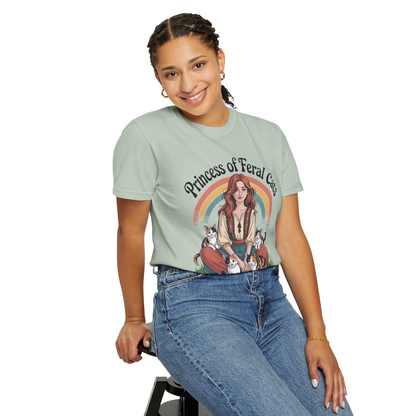 Person wearing a t-shirt with a graphic design and text, sitting on a stool against a white background